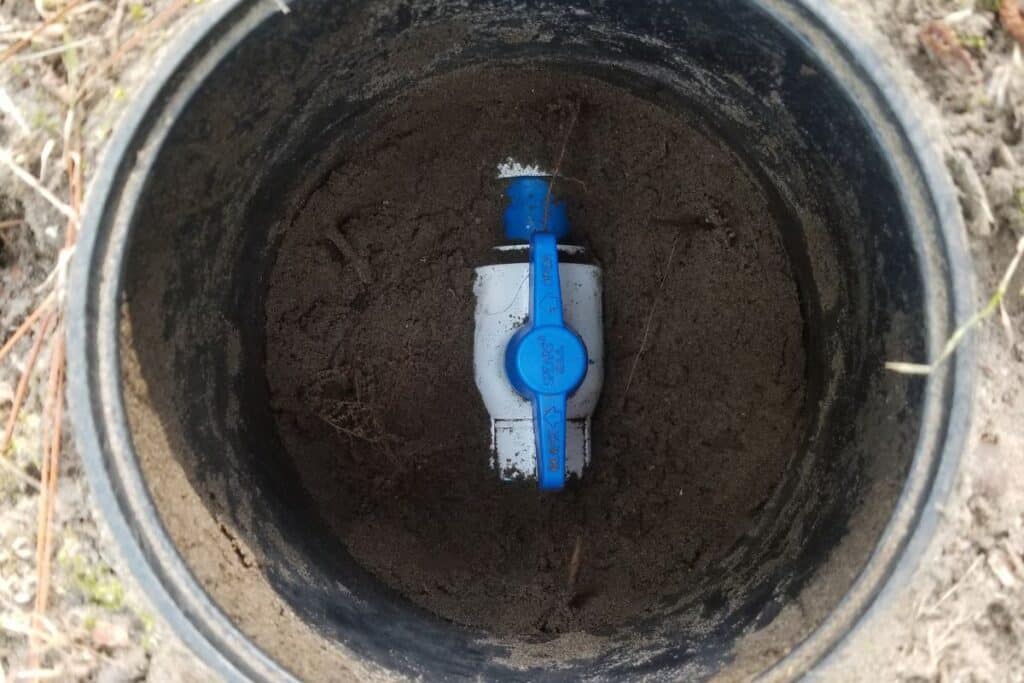 Underground water valve inside utility access pipe