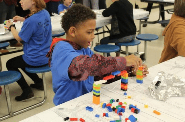 Child participating in educational STEM activity sponsored by Henry Plumbing
