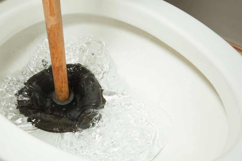 Drain cleaning service removing clogged bathroom drain