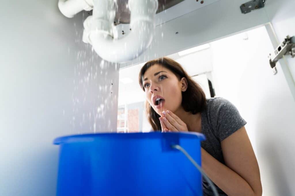 Homeowner dealing with plumbing overflow and emergency water damage