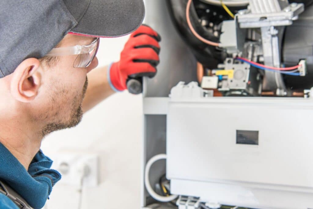 Plumbing technician repairing under-sink plumbing connections