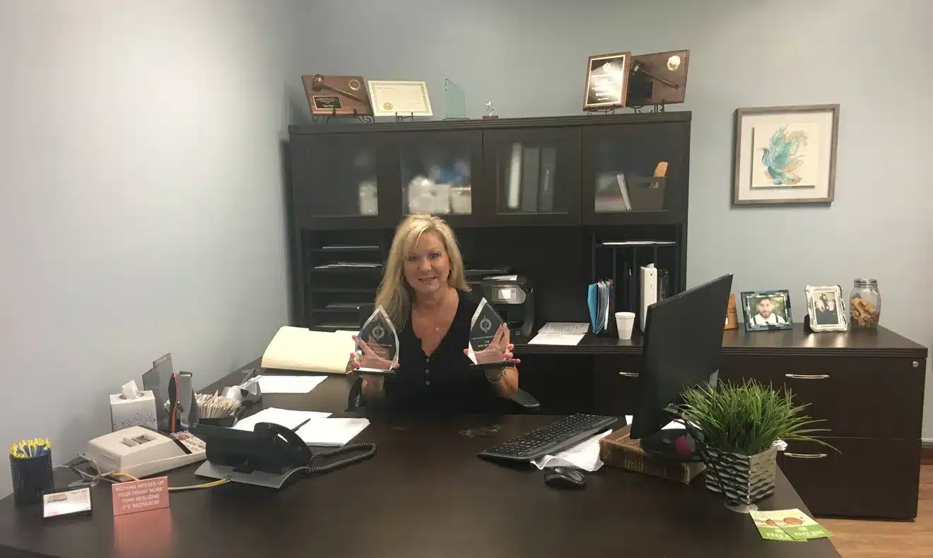 Tonya Reed holding awards in the Henry Plumbing office in Savannah Georgia