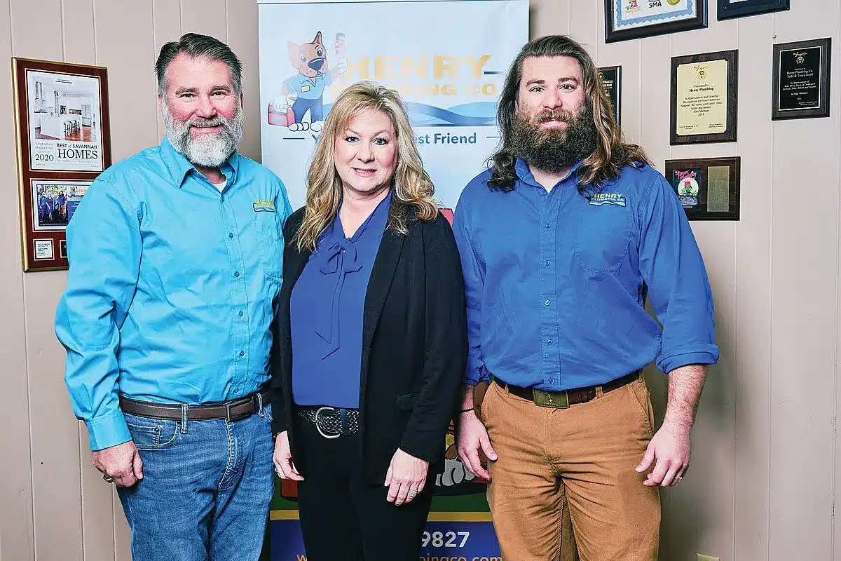 Todd Reed, Tonya Reed and Tanner Reed posing together inside office and representing three generations of their family business