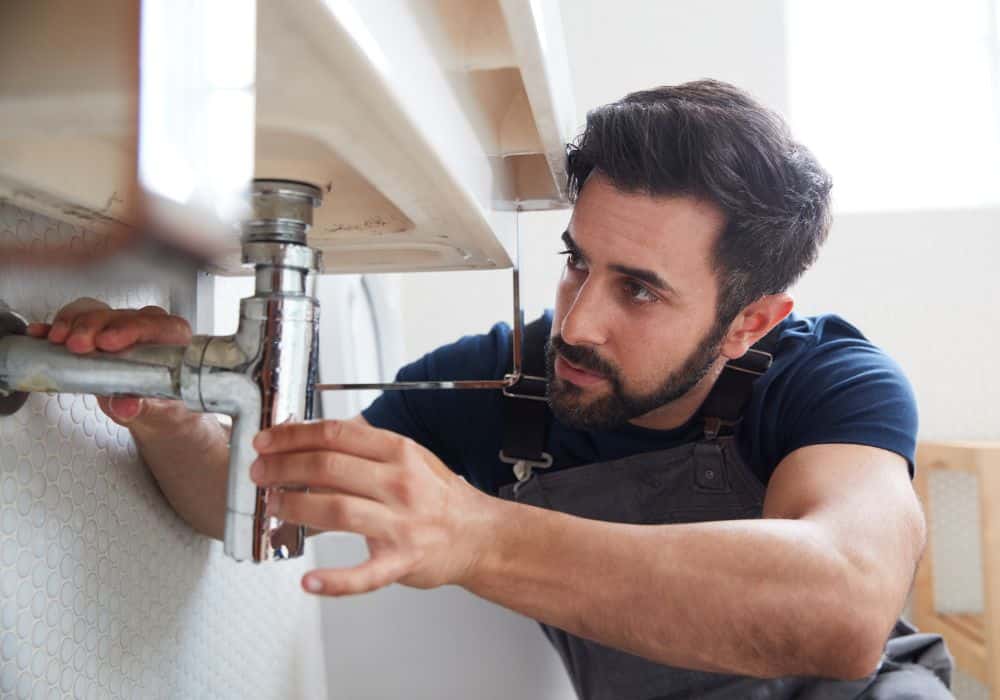 Professional plumber repairing kitchen sink plumbing in Savannah GA
